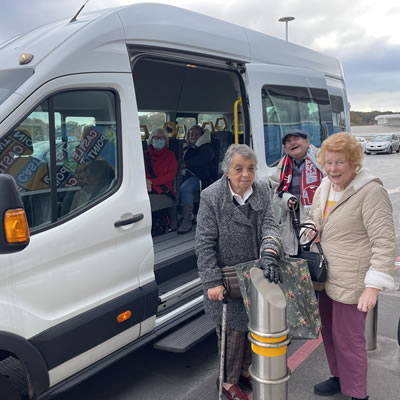 people stood besides a sedcat bus