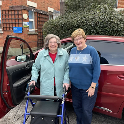 two ladies stood infront of a car
