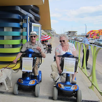 2 people on mobility scooters